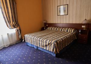 
a bedroom with a bed and a dresser at Belvedere Nevsky Business Hotel in Saint Petersburg
