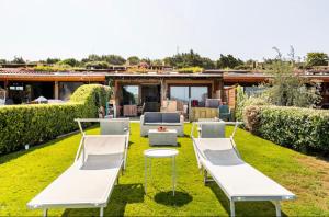 ポルト・ポッロにあるVilletta a schiera con giardino - porto polloの白いベッド2台、テーブルと椅子が備わる裏庭