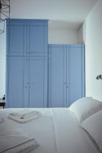 Schlafzimmer mit blauen Schränken und einem weißen Bett in der Unterkunft Studio Kocis in Monolithos