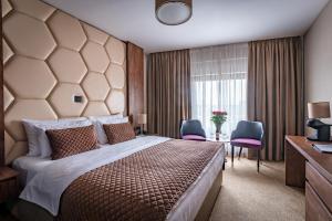 a bedroom with a large bed and two chairs at Amsterdam Hotel in Belgrade