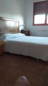 ein großes weißes Bett in einem Schlafzimmer mit Fenster in der Unterkunft Casa la Era in Salas Bajas