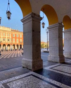 an archway in a courtyard with a building in the background at La Maioneta Vieux-Nice in Nice