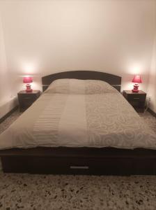 a bedroom with a large bed with two lamps at Le pain perdu de germaine in Château-Gontier
