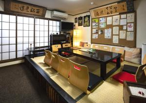 een eetkamer met een tafel en stoelen bij Maguro House in Osaka
