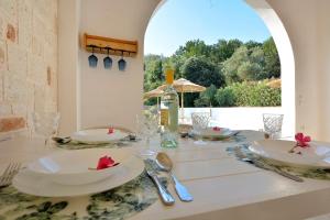 een tafel met witte borden en een fles wijn bij Villa Siga - Siga in Kokkínion