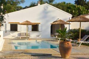 een villa met een zwembad en parasols bij Villa Siga - Siga in Kokkínion +21 foto's