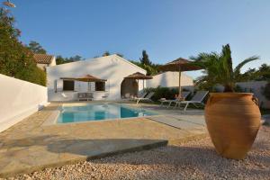 een zwembad met een grote vaas naast een huis bij Villa Siga - Siga in Kokkínion