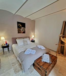 1 dormitorio con 1 cama con 2 toallas en LA MAISON DE LIVIA, chambres et table d'hôtes, en Sauzet