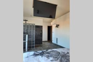 Habitación con ducha y TV en la pared. en Rêves de vie, studio Port Miou perle rare à Cassis, en Cassis