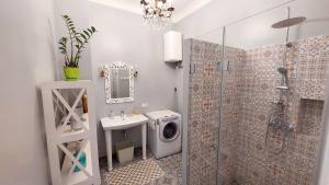 a bathroom with a shower and a sink and a washing machine at Inn Home Apartments-Olimpiysky Stadium area in Kyiv
