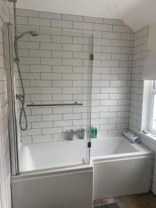 a white bath tub with a glass shower door at Perfect base for 8, pets allowed in Tenby +33 photos