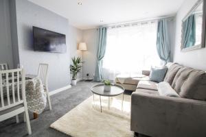 a living room with a couch and a table at Modern and Stylish Apartment- Short Walk to Beach in Paignton