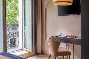a room with a table and a window and a chair at Hôtel de la Bourdonnais in Paris