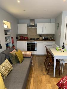 una sala de estar con un sofá y una mesa en Cosy Studio Flat, pets allowed, en Tenby