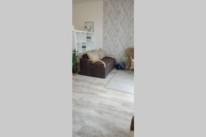 uma sala de estar com um sofá e uma cadeira em Apartmán Dvojka em Náchod