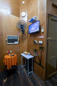 a room with a table and a tv on a wall at Sip N' Camp in Bangkok