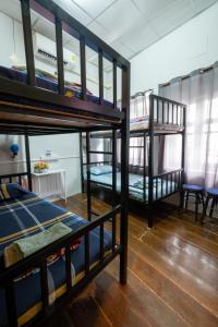 Zimmer mit 3 Etagenbetten und einem Tisch in der Unterkunft Sip N' Camp in Bangkok