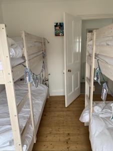 a room with two bunk beds and a hallway at Hobbes Cottage, pets allowed in Tenby