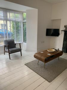 een woonkamer met een salontafel en een stoel bij Hobbes Cottage, pets allowed in Tenby