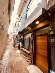 une ruelle vide avec un bâtiment et un garage dans l'établissement 三田包棟旅宿MITA Inn, à Tainan