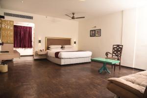 a bedroom with a bed and a table and a couch at Hotel Sabareesh Park in Madurai