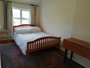 a small bedroom with a bed and a window at Lisieux House on Lough Neagh in Aghalee