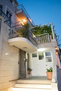 a house with a white door and a balcony at Apartments Bora in Neum