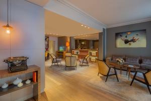 a living room with a couch and a table at Hôtel Le Tourville by Inwood Hotels in Paris