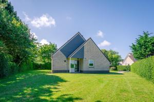 ein Haus mit einem Rasenplatz in der Unterkunft Villapark Kamperfoelie 73 in De Koog