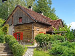 a small wooden house with a red door and stairs at Pension Vuglec Breg in Krapina