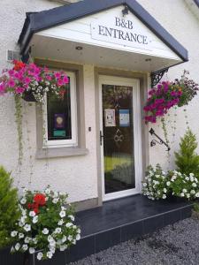 um edifício com flores na frente de uma porta em The Laurels Bed & Breakfast Lodge em Omagh