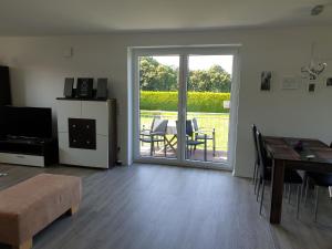 a living room with a sliding glass door with a table and chairs at Naturpur die Wellnessoase in Leezen