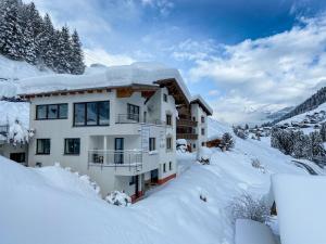 un edificio cubierto de nieve en las montañas en Apartments Kappl, en Kappl