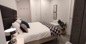 1 dormitorio con 1 cama con almohadas blancas y negras en GRUPO LIMCOTEl PERLA 1, en Córdoba