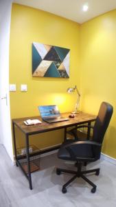 una oficina con escritorio, ordenador portátil y silla en CasaCity Orléans Sud - 2 chambres - parking privé, en Orléans