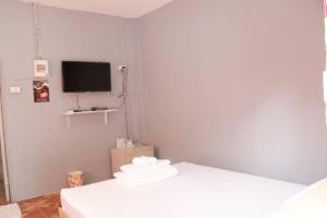 a small room with a bed and a tv at The Money Inn in Khon Kaen