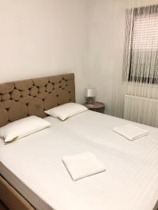 een groot wit bed met twee witte handdoeken erop bij CONFORT GuestHouse in Oradea