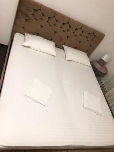 een groot wit bed met 2 kussens erop bij CONFORT GuestHouse in Oradea