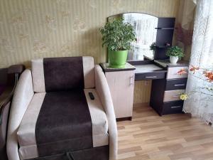 een kleedkamer met een stoel en een spiegel bij Апартаменти в центрі міста in Kamjanets-Podilsky
