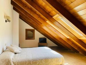 a bedroom with a bed and wooden ceilings at CASA ADOSADA TAULL by IMMOVALL in Taüll