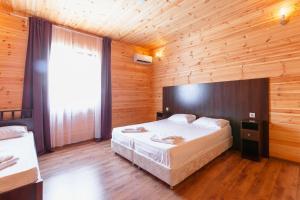 a bedroom with a large bed in a wooden room at AMSHIN-Pitsunda in Pizunda