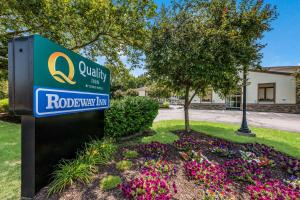 a sign for a road way inn with flowers at Quality Inn Poughkeepsie in Poughkeepsie