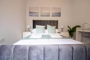 ein großes Bett mit weißer Bettwäsche und blauen Kissen in der Unterkunft The Terrace on Torquay Harbour in Torquay