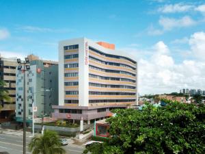 um edifício branco alto numa rua da cidade em ibis Maceio Pajuçara em Maceió