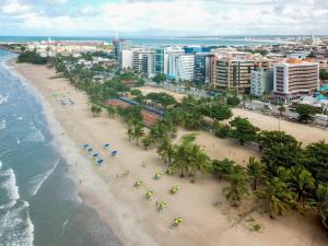 uma vista aérea de uma praia com palmeiras e do oceano em ibis Maceio Pajuçara em Maceió