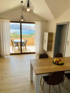 a kitchen and dining room with a table and a view at Mare E Sabbia in Lopar