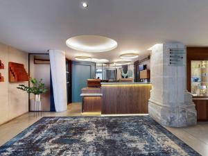 a lobby with a fireplace in the center of a building at Mercure Poitiers Centre in Poitiers