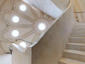 eine Treppe in einem Gebäude mit kreisförmigen Fenstern in der Unterkunft Mercure Poitiers Centre in Poitiers