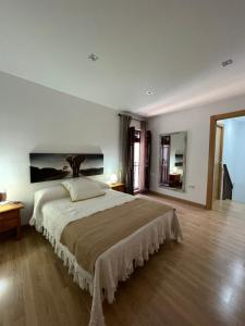 sypialnia z dużym łóżkiem i dużym obrazem na ścianie w obiekcie Casa rural Los Abuelos w mieście Monachil
