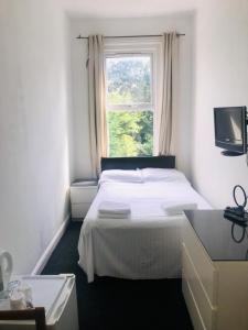 Un pat sau paturi într-o cameră la Amhurst Hotel